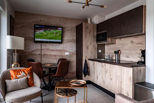 un salon avec une télévision sur un mur dans l'établissement LE ST-EXUPERY - Studio de standing - Vue mer - Terrasse - Parking privé - A 150 m de la Plage, à Berck-sur-Mer