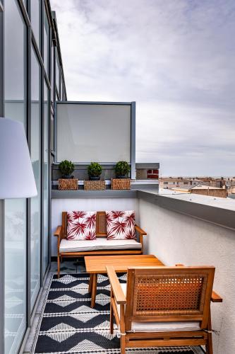 - un balcon avec un canapé et deux bancs dans un bâtiment dans l'établissement LE ST-EXUPERY - Studio de standing - Vue mer - Terrasse - Parking privé - A 150 m de la Plage, à Berck-sur-Mer