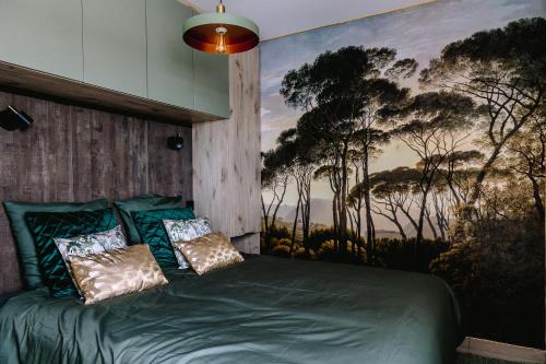 - une chambre avec un lit vert orné d'une peinture murale dans l'établissement LE ST-EXUPERY - Studio de standing - Vue mer - Terrasse - Parking privé - A 150 m de la Plage, à Berck-sur-Mer