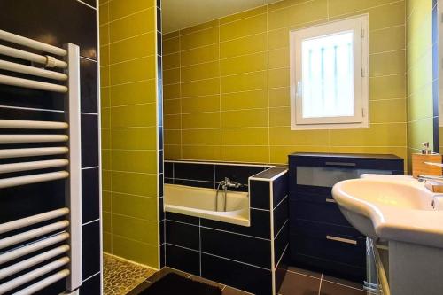 La salle de bains jaune est pourvue d'un lavabo et d'une baignoire. dans l'établissement Villa 3 chambres avec piscine, à Saint-Laurent-dʼAigouze