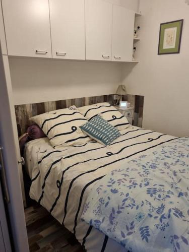 une chambre avec un lit avec une couverture bleue et blanche dans l'établissement Appartement sur la marina, à Saint Cyprien Plage