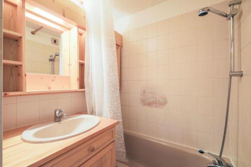 bagno con lavandino, vasca e specchio di Résidence Arche - maeva Home - Studio 4 Personnes - Confort 97 ad Arâches