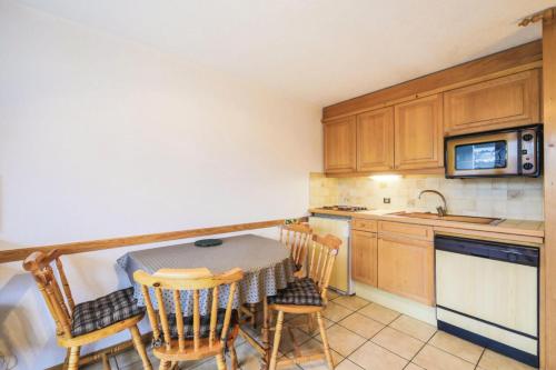une cuisine avec une table et des chaises dans une cuisine dans l'établissement Résidence Arche - maeva Home - Studio 4 Personnes - Confort MAE-3695, à Arâches-la-Frasse