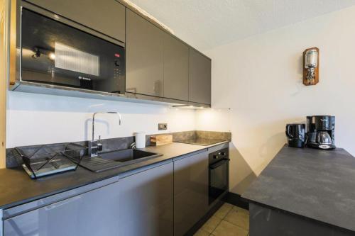 une cuisine avec un évier et un comptoir dans l'établissement Résidence Arche - maeva Home - Appartement 2 Pièces 4 Personnes - Sélection MAE-3699, à Arâches-la-Frasse
