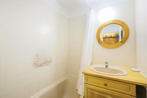 une salle de bain avec un lavabo, un miroir et une baignoire dans l'établissement Résidence Arche - maeva Home - Appartement 2 Pièces 4 Personnes - Sélection MAE-3699, à Arâches-la-Frasse
