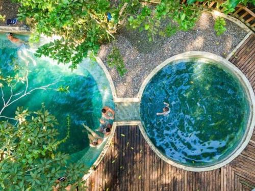 una vista aérea de una piscina con gente nadando en ella en Casa Prana, Termales, Nuqui, en Nuquí