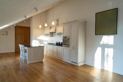 a kitchen with white cabinets and a table with chairs at Villa Langberg Spa in Ventspils