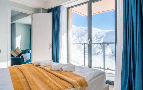 a bedroom with a bed and a large window at New Gudauri Apartments in Gudauri