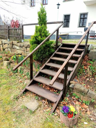 a set of stairs in a yard with flowers at Gasthof Oberschmiede in Auf der Wiese
