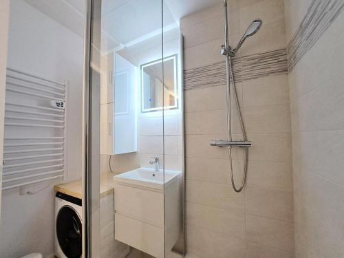 La salle de bains est pourvue d'une douche, d'un lavabo et d'un lave-linge. dans l'établissement Résidence Aldébaran - maeva Home - Appartement 2 Pièces 6 Personnes - Prestige MAE-3791, à Arâches-la-Frasse