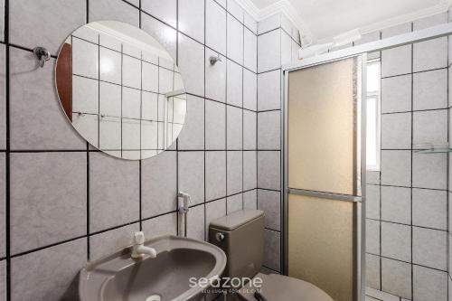 La salle de bains est pourvue d'un lavabo, de toilettes et d'un miroir. dans l'établissement Apto Vista para a Praia em Canasvieiras SEN0105, à Florianópolis
