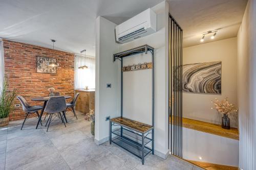 a dining room with a table and a brick wall at Villa Milly Groznjan in Grožnjan
