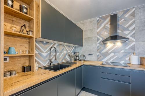 a kitchen with blue cabinets and a sink at Villa Milly Groznjan in Grožnjan