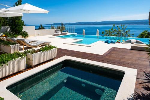 una piscina in un cortile con vista sull'acqua di Seaview villa Agata with heated infinity pool a Lokva Rogoznica