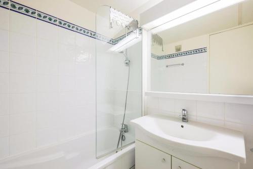 a white bathroom with a sink and a mirror at Résidence Aldébaran - maeva Home - Appartement 2 Pièces 6 Personnes - Confort 06 in Arâches-la-Frasse