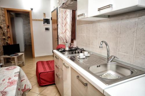 eine Küche mit einer Spüle und einem roten Stuhl in der Unterkunft CASA DEL MORO in Trapani