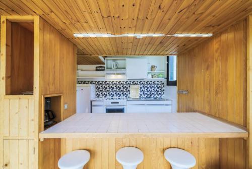 une cuisine avec des murs en bois et une table avec quatre chaises dans l'établissement Résidence Aldébaran - maeva Home - Appartement 2 Pièces 6 Personnes - Budget MAE-3807, à Arâches-la-Frasse