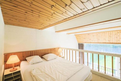 une chambre avec un lit et une grande fenêtre dans l'établissement Résidence Aldébaran - maeva Home - Appartement 2 Pièces 6 Personnes - Budget MAE-3807, à Arâches-la-Frasse