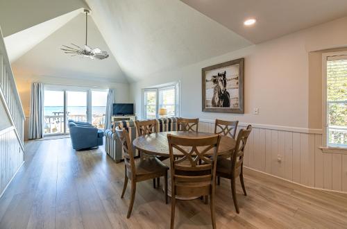 a dining room with a table and chairs at D4414 Exhibit Sea. Soundfront, Stunning Sunsets, Pier, Private Pool & Hot Tub! in Sanderling