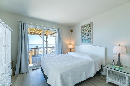 a white bedroom with a bed and a balcony at D4414 Exhibit Sea. Soundfront, Stunning Sunsets, Pier, Private Pool & Hot Tub! in Sanderling