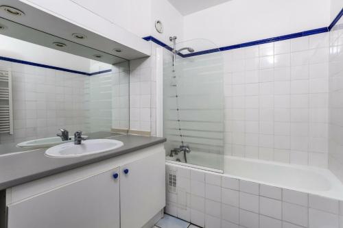 une salle de bain avec un lavabo, une baignoire et un miroir dans l'établissement Résidence Capricorne - maeva Home - Appartement 2 Pièces 6 Personnes - Confort MAE-3832, à Arâches-la-Frasse