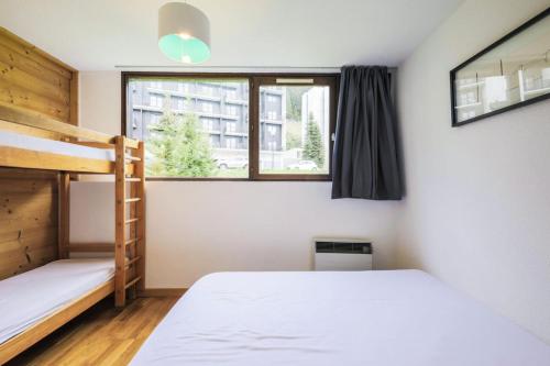 une chambre avec deux lits superposés et une fenêtre dans l'établissement Résidence Castor - maeva Home - Appartement 2 Pièces 6 Personnes - Confort MAE-3847, à Arâches-la-Frasse