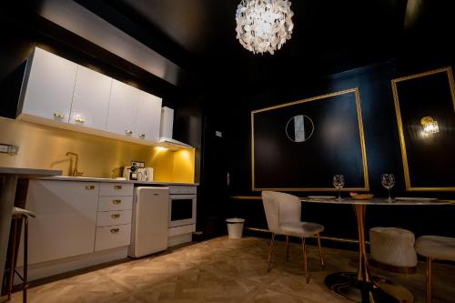 a kitchen with white cabinets and a table and a chandelier at Appartement d'exception avec Jacuzzi in Villefranche-sur-Saône