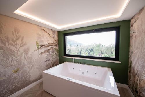 a bathroom with a large tub and a window at La Dependance Luxury Bed and Breakfast in Fondi