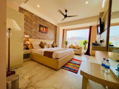 ein Schlafzimmer mit einem Bett und einem Sofa in einem Zimmer in der Unterkunft Hotel The Tirath View in Haridwar