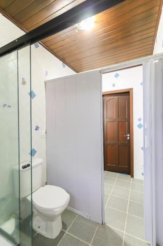 a bathroom with a toilet and a glass door at Hospedaria Fabulosa in Paraty