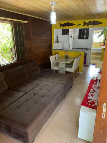 ein Wohnzimmer mit einem Sofa und einer Küche in der Unterkunft Casa da Lívia - Ilha do Mel in Paranaguá