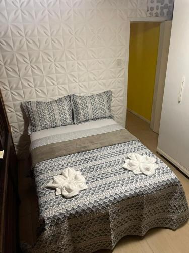 ein Bett mit zwei weißen Handtüchern darüber in der Unterkunft Casa da Lívia - Ilha do Mel in Paranaguá