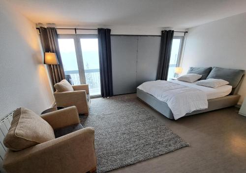 une chambre avec un lit, un canapé et une chaise dans l'établissement Résidence La Petite Ourse - maeva Home - Appartement 4 Pièces 6 Personnes - Sélection MAE-3904, à Arâches-la-Frasse