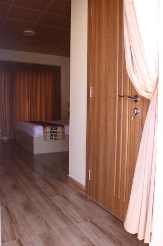 a bedroom with a bed and a wooden door at Lina Dreamland Resort in Billah