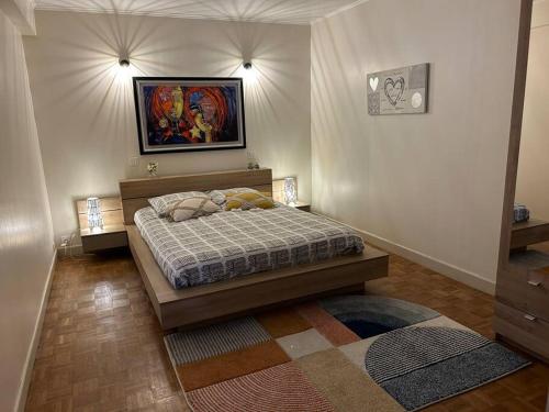 1 dormitorio con 1 cama y una pintura en la pared en Longère sur Loire, 