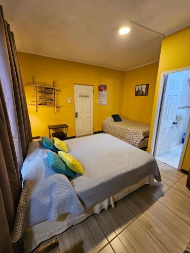 a bedroom with a bed and a yellow wall at Hostal Pucara Molina in Molina