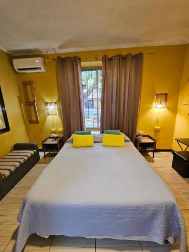 a bedroom with a large bed with yellow walls at Hostal Pucara Molina in Molina