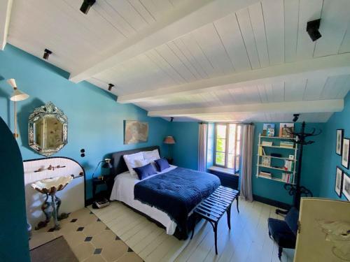 雷島林灘的住宿－Maisons 322 - La Secrète，一间拥有蓝色墙壁的卧室,配有一张床和一张桌子