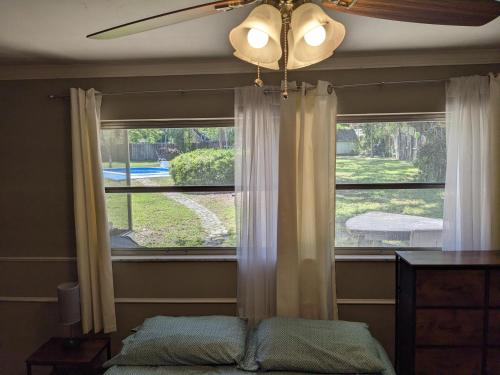 a bedroom with a window and a ceiling fan at Executive Pool Home in Tampa