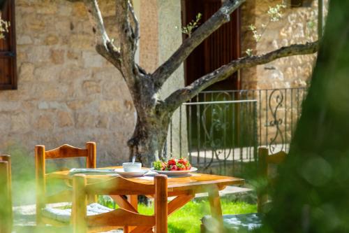 Una mesa de madera con un bol de fruta y un árbol. en VILLA ISOLOTTO a 150 m dal mare, en Santa Maria Navarrese