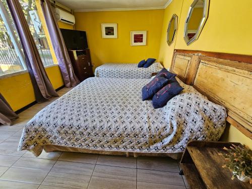 a bedroom with two beds with blue pillows on them at Hostal Pucara Molina in Molina