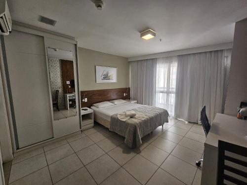 um quarto com uma cama e um espelho grande em F1614 FG Apart Hotel Fusion WIFI Piscina Academia em Brasília