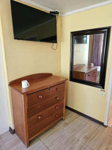 a bedroom with a dresser and a large mirror at Hostal Pucara Molina in Molina
