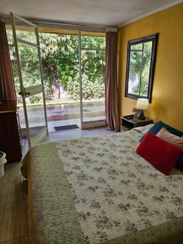 a bedroom with a large bed and a large window at Hostal Pucara Molina in Molina