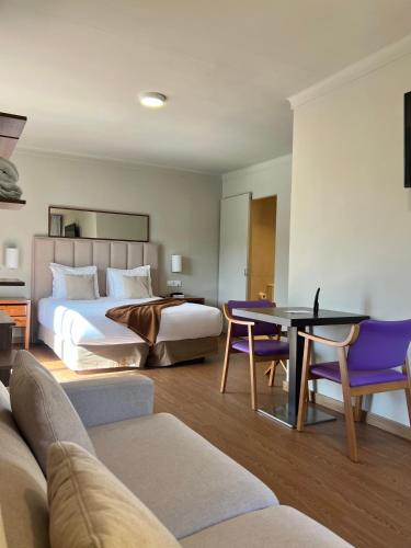 a hotel room with a bed and a table and chairs at Hotel Aatu - Adults Only in Peratallada