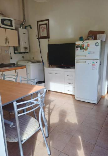 a kitchen with a table and a white refrigerator at El Amanecer in Ushuaia