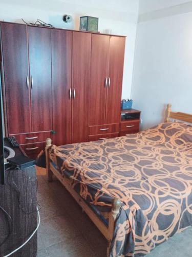 sypialnia z łóżkiem i drewnianymi szafkami w obiekcie El Amanecer w mieście Ushuaia
