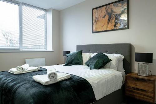 een slaapkamer met een groot bed en handdoeken bij Manchester 1Bed Apartment, Free Parking For Two, Long Term Discounts in Manchester