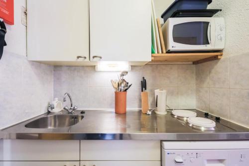 une cuisine avec un évier et un micro-ondes dans l'établissement Résidence Pollux - maeva Home - Studio 4 personnes - Budget MAE-4213, à Arâches-la-Frasse
