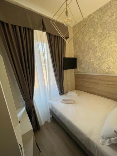 a small bedroom with a bed with a window at ROME'S GLORIA HOTEL in Rome